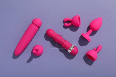 Téléchargez les photos : Une collection de jouets sexuels sur un fond violet. - en image libre de droit
