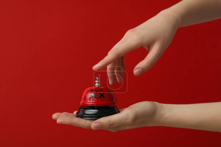 Glocke für Sex auf rotem Hintergrund.
