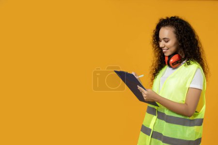 Photo for A girl in noise-absorbing headphones and a folder - Royalty Free Image