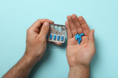 Téléchargez les photos : Pilules de viagra bleu dans la main d'un homme - en image libre de droit