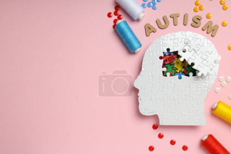 Téléchargez les photos : Puzzle tête, mot autisme, fils et boutons sur fond rose, espace pour le texte - en image libre de droit