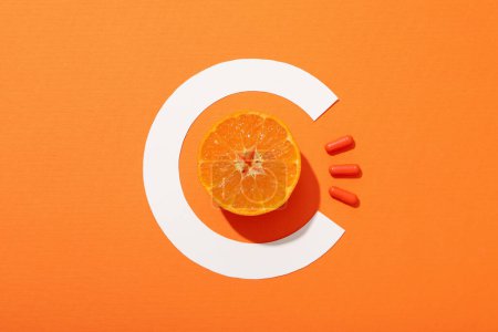 Foto de Vitamina C en cítricos, sobre fondo naranja. - Imagen libre de derechos