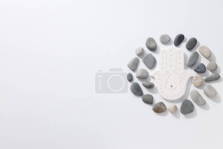 Photo for Hamsa and stones on white background, space for text - Royalty Free Image
