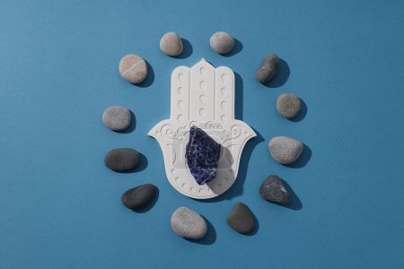 Photo for Hamsa, stones and natural stone on blue background, top view - Royalty Free Image
