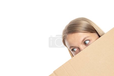 Foto de PNG, Una joven mira desde detrás de la caja, aislada sobre fondo blanco - Imagen libre de derechos