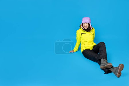 Foto de Una chica con un traje de esquí sobre un fondo azul. - Imagen libre de derechos