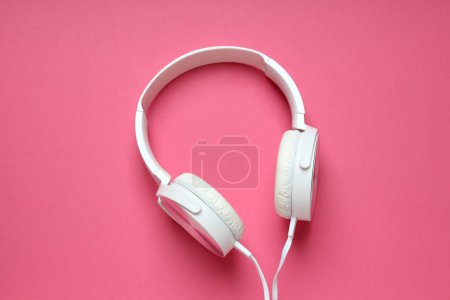 Photo for White, on-ear headphones with a wire on a pink background. - Royalty Free Image