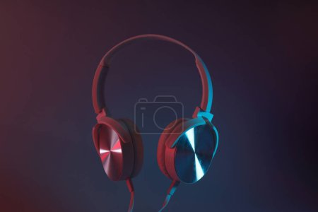 Photo for White, over-the-ear headphones with a wire on a colored, dark background. - Royalty Free Image