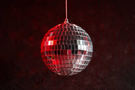 The disco ball is illuminated with red light