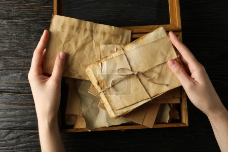Foto de Antiguas cartas de amor en manos humanas, sobre un fondo oscuro. - Imagen libre de derechos