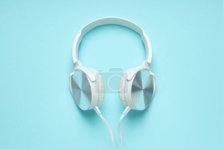 Photo for White, over-the-ear headphones with a wire on a blue background. - Royalty Free Image