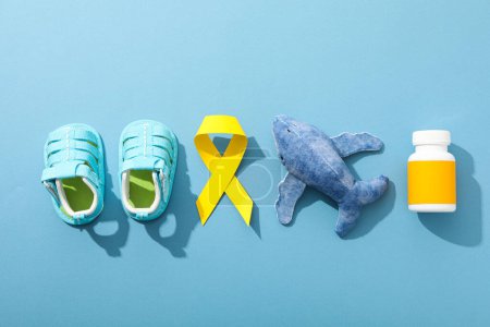 Téléchargez les photos : Chaussures bleues pour enfants avec un ruban jaune et des médicaments - en image libre de droit