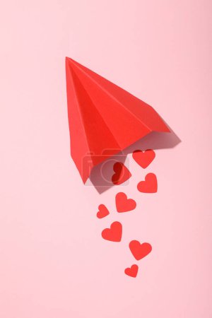 Téléchargez les photos : Avion en papier rouge avec des coeurs sur un fond rose. - en image libre de droit