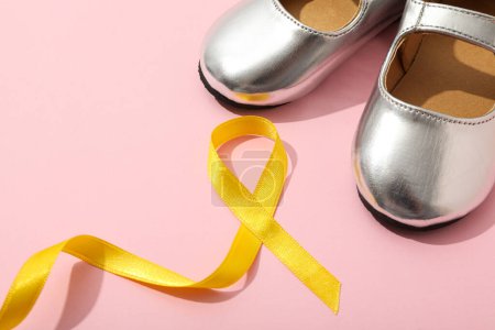 Téléchargez les photos : Chaussures enfant argentées avec un ruban jaune - en image libre de droit
