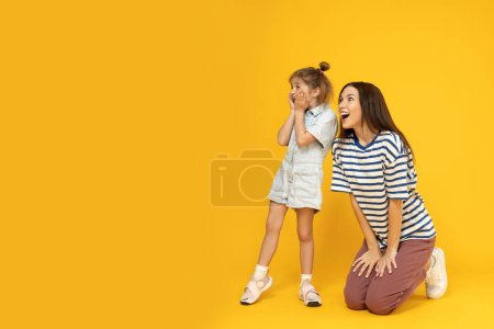 Téléchargez les photos : Mère et fille jouent, sur fond jaune. - en image libre de droit