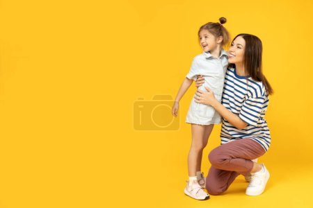Téléchargez les photos : Mère et fille parlent, sur fond jaune. - en image libre de droit