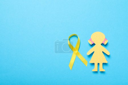 Téléchargez les photos : Une figure en papier d'une fille avec un ruban jaune - en image libre de droit