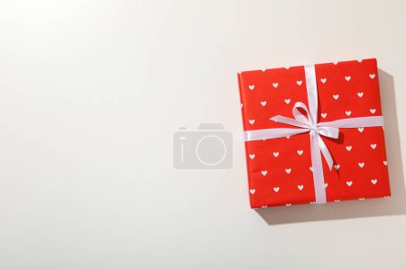 Téléchargez les photos : Boîte cadeau rouge sur un fond cassé doux. - en image libre de droit