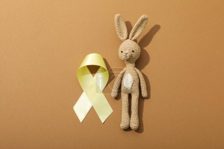 Téléchargez les photos : Un lapin jouet doux avec un ruban jaune - en image libre de droit