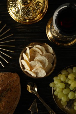 Foto de Pan, uvas en tazón de oro y copa de vino sobre fondo de madera, vista superior - Imagen libre de derechos