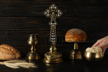 Foto de Pan, mano, copa dorada y cruz sobre fondo de madera - Imagen libre de derechos