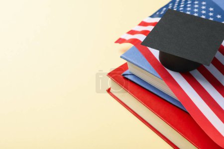 Téléchargez les photos : Chapeau et livres diplômés et drapeau américain, sur fond rouge. - en image libre de droit