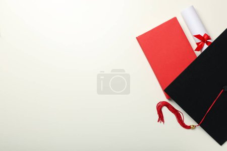 Téléchargez les photos : Un chapeau de diplômé et des livres, sur un fond clair. - en image libre de droit