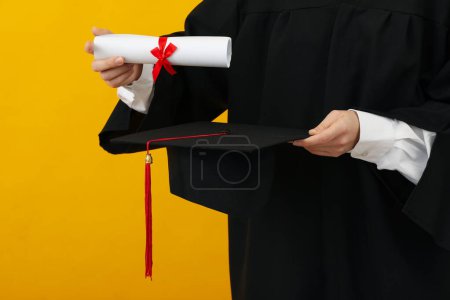 Téléchargez les photos : Diplôme d'un diplômé universitaire, sur fond jaune. - en image libre de droit