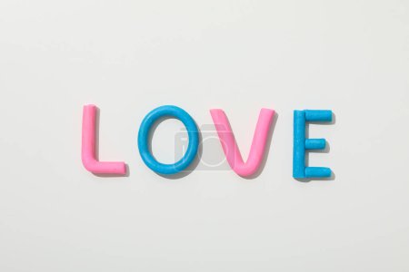 Das Wort "Liebe" besteht aus farbigem Knetmasse auf weißem Hintergrund.