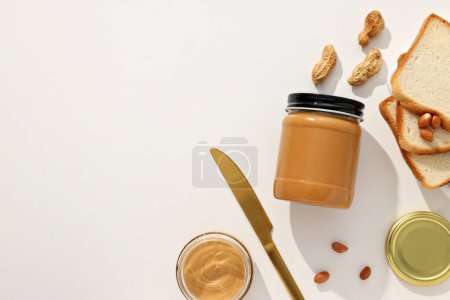 Peanut paste in a glass jar, on a light background.