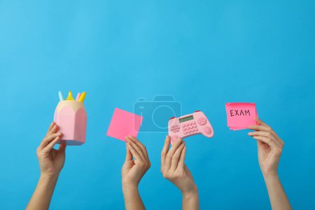 Photo for Stationery and exam record, in hands on a blue background. - Royalty Free Image