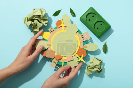 Papiermodell der Erde mit grünen Steckdosen