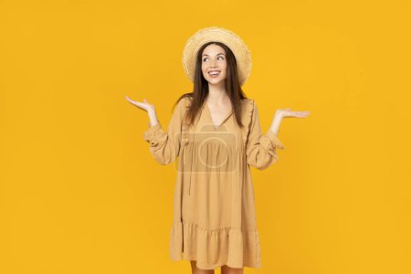 Happy young woman in a hat on yellow background, space for text