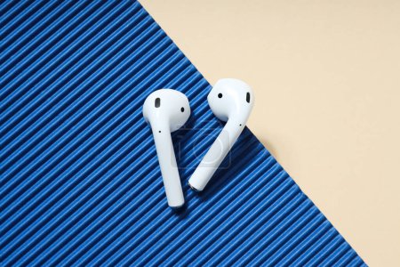 White, earphones on a blue and peach background.