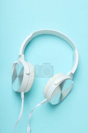 Photo for White, over-the-ear headphones with a wire on a blue background. - Royalty Free Image