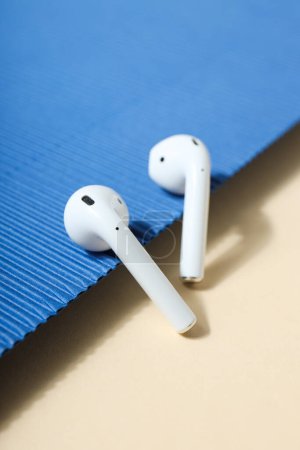 White, earphones on a blue and peach background.