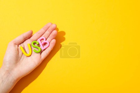 La palabra "USB" en manos hechas de plastilina de color.