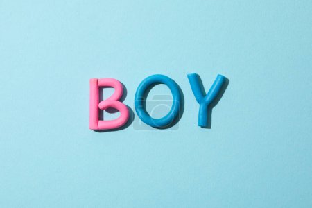 Das Wort "Junge" besteht aus farbigem Knetmasse auf blauem Hintergrund.