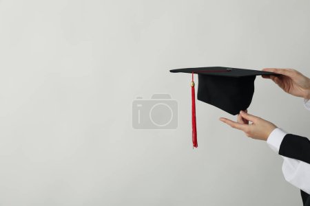 Le chapeau d'un diplômé d'université, entre ses mains.