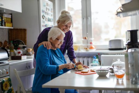 Photo for Woman spending time with her elderly mother at home - Royalty Free Image