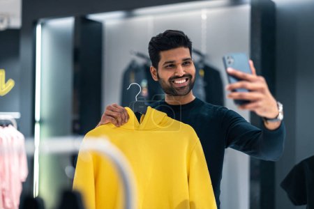 Photo for Young man shopping in clothing store - Royalty Free Image