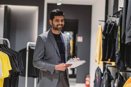Photo for Young man working in clothing store - Royalty Free Image