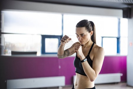 Photo for Portrait of a young woman boxing in a gym - Royalty Free Image