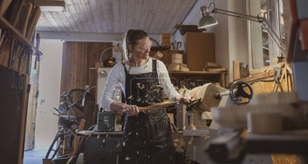 Téléchargez les photos : Artisanat sculptant du bois dans un atelier de menuiserie - en image libre de droit