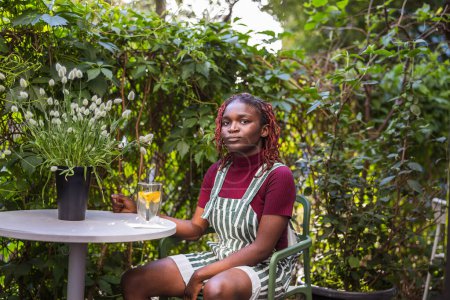 Photo for Portrait of a black non-binary person sitting in an outdoor cafe - Royalty Free Image