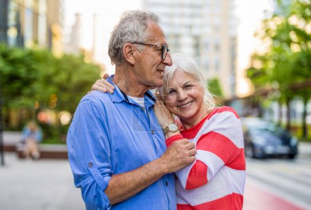 Téléchargez les photos : Portrait d'un heureux couple de personnes âgées embrassant dans la ville - en image libre de droit