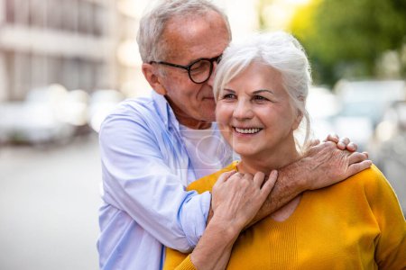 Téléchargez les photos : Portrait d'un heureux couple de personnes âgées embrassant dans la ville - en image libre de droit