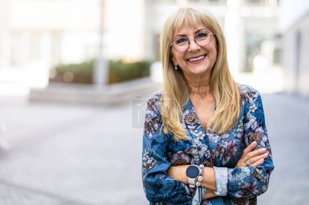 Téléchargez les photos : Portrait d'une femme âgée heureuse en lunettes debout à l'extérieur - en image libre de droit