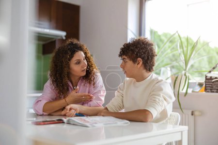 Photo for Mother helping her son with homework at home - Royalty Free Image