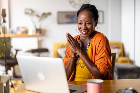Foto de Mujer sonriente trabajando en el ordenador portátil en casa - Imagen libre de derechos